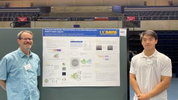 Student and faculty mentor smiling together in front of the same RNA-editing enzyme research poster at a UC Davis symposium.